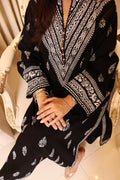 Naqsh black lawn kurta with white block-printed neckline and sleeve borders, seated view from above