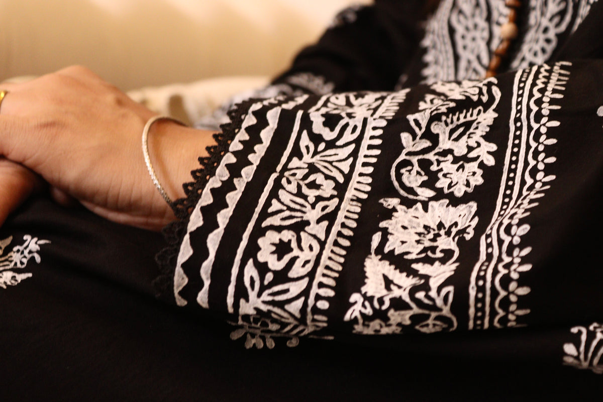 Close-up of Naqsh sleeve with white floral block print and black lace edging